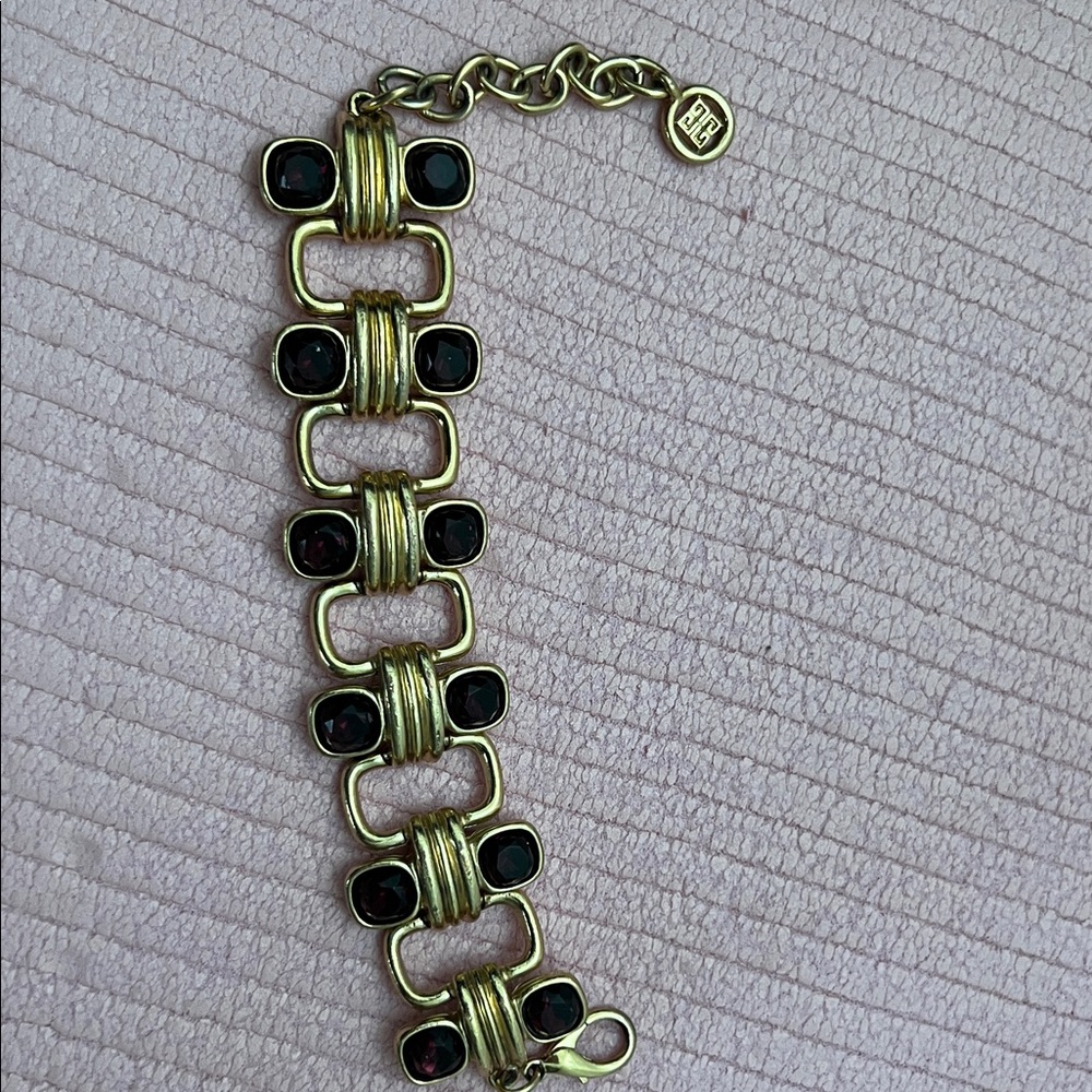 Givenchy …a gold toned metal link design set with dark purple  stones